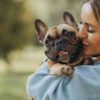 young-woman-with-her-pet-french-bulldog-in-park